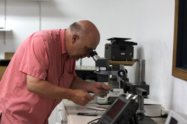 Rhett F Spencer looking through microscope